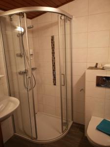 una doccia con una porta in vetro in un bagno di Hotel Wirt Z'Minsta ad Altmünster Altre 37 foto
