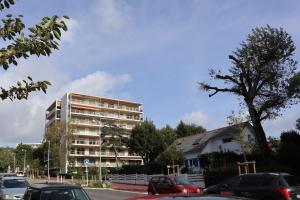 拉波勒Lutin Vue Baie La Baule - Appartement T2 design et connecté的一座高楼，停车场里停满了汽车