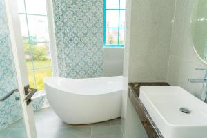 a bathroom with a tub and a toilet and a sink at La Casa Boutique Hotel in Vung Tau