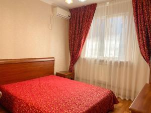 アドレルにあるГостевой дом Альбина 4のベッドルーム1室(赤いベッド1台、窓付)