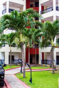 a row of palm trees in front of a building at Accra Fine Suites - Holi Flats Airport Residential in Accra