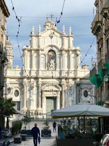 a large white building with people walking in front of it at ERASMO 19 Luxury Home in Catania