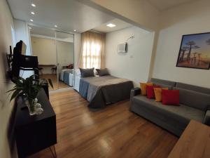 a living room with two beds and a couch at Vem pro Arouche/República -Studio- 4 min do Metrô in Sao Paulo