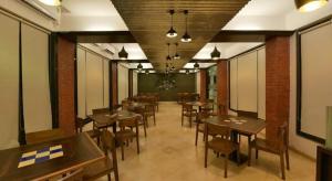 a restaurant with tables and chairs in a room at Ivy Pali Studio Rooms (Near Imagica), Dhokshet in Jambhulpāda