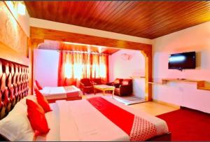 a hotel room with a bed and a living room at Hotel River INN in Manāli