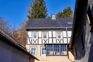 ein weißes und schwarzes Haus mit schwarzem Dach in der Unterkunft Ritterstube - Eifelstuben mit Charme, Nähe See und Burg, außergewöhnlich, Vulkaneifel in Ulmen