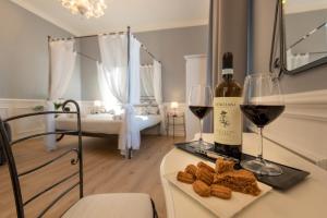uma garrafa de vinho e um prato de pão e copos de vinho em VILLA BERNASCONI em Narzole