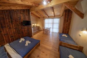 two beds in a room with wooden walls at Apartment Ve Mlýně in Teplice nad Metují