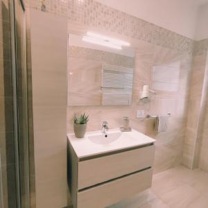 W białej łazience znajduje się umywalka i lustro. w obiekcie CASA VACANZE DA GABRI w mieście Tirano