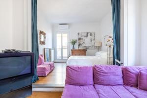 uma sala de estar com um sofá roxo e uma televisão em Spanish Step Rooftop Boutique Apartment Rome em Roma