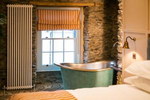 a bathroom with a tub next to a window at The White House in Bowness-on-Windermere