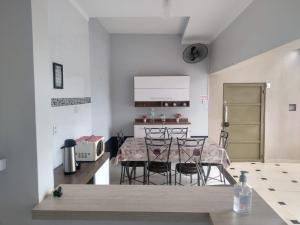 a kitchen and dining room with a table and chairs at Pousada Vitória Régia Olímpia in Olímpia