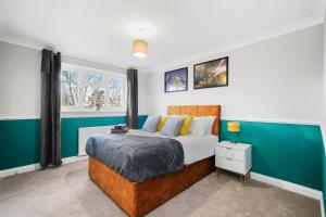 1 dormitorio con cama y pared verde en Stunning Cambridge Abode - Garden - Pet Friendly, en Whittlesford