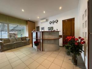 uma sala de estar com um sofá e uma mesa com flores vermelhas em Gusarskiy Hotel and Apartment em Kiev