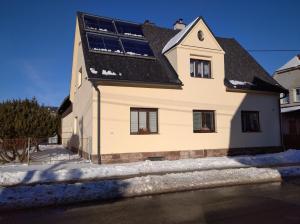 uma casa com painéis solares na lateral em Ubytování Sedlařík Mladé Buky em Mladé Buky