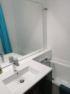 a bathroom with a white sink and a mirror at Studio 4 personnes au pied des pistes in Le Corbier