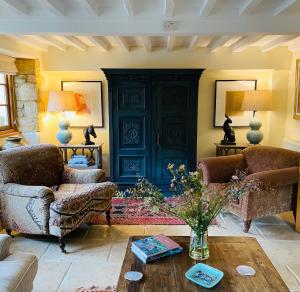 a living room with two couches and a table at Jasmine Cottage in Chipping Campden