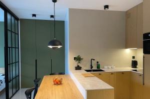 a kitchen with a wooden table and green walls at Turbo Apartament pod Szyndzielnią i Dębowcem in Bielsko-Biala