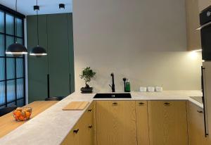 een keuken met houten kasten en een aanrecht bij Turbo Apartament pod Szyndzielnią i Dębowcem in Bielsko-Biala