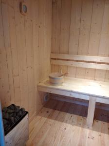 uma sauna de madeira com uma tigela num banco em Séjour en amoureux avec jacuzzi et sauna em Balbigny