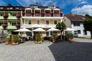 ein Hotel mit Tischen und Sonnenschirmen davor in der Unterkunft Gasthof Hotel Reif in Königstein in der Oberpfalz