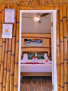 ein Schlafzimmer mit einem Bett in einem Blockhaus in der Unterkunft GEM Crystal Water Resort in Davao City