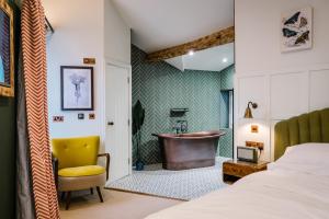 1 dormitorio con cama y baño con bañera en The White House en Bowness-on-Windermere