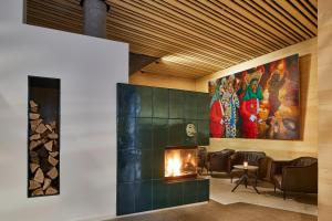 a lobby with a fireplace and paintings on the wall at ElzLand Hotel 9 Linden "Ferienwohnung" in Elzach