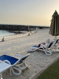 uma pessoa deitada numa cadeira na praia em Incredible Ocean View Studio Aprtment in Al Marjan Island em Ras al-Khaimah