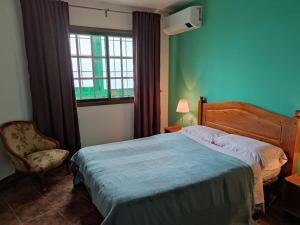 sypialnia z łóżkiem, krzesłem i oknem w obiekcie Apartamento Vista al Mar w mieście Los Silos