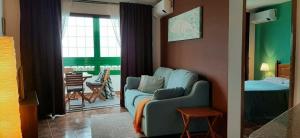 salon z niebieską kanapą i sypialnią w obiekcie Apartamento Vista al Mar w mieście Los Silos
