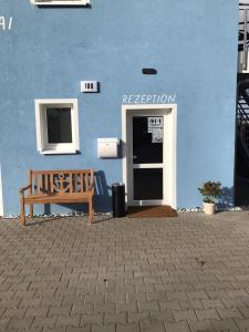 un edificio blu con una panchina davanti ad una porta di Boardinghouse am Borkumkai a Emden