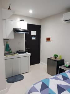 uma cozinha com armários brancos e uma porta preta em Skymagz 812 at Cityscape Residences em Bacolod