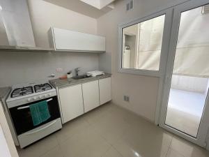 cocina pequeña con fogones y ventana en Dpto Moderno - 1 dormitorio, hasta 4 personas en Tandil