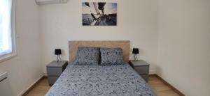 una camera con un letto con due comodini di Le jardin des pensées a Le Boulou