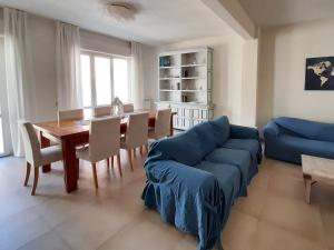 Una sala de estar con un sofá azul y una mesa. en Casa di Nicola, en Viareggio