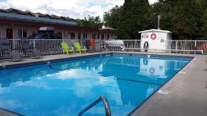 una grande piscina con sedie e un edificio di Swiss Sunset Inn a Penticton