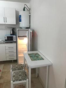 a kitchen with a white table and a refrigerator at Apartamentos Don Bosco in Paso de los Libres
