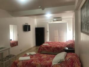 um quarto de hotel com duas camas e um espelho em Apartamentos Don Bosco em Paso de los Libres