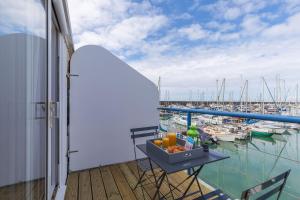 a balcony with a table and a view of a marina at On the Water 3 with Free Parking - By My Getaways in Brighton & Hove