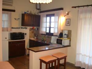 uma cozinha com um lavatório e um balcão com bancos em Studio Nausica... a sense of paradise! em Agia Pelagia Chlomou