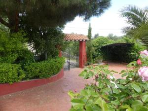 un giardino con cancello nero e rose rosa di LA CASA GRANDE a Siviglia