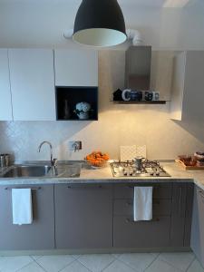 a kitchen with a sink and a stove top oven at AGM Suite Rome Airport FCO - Attico Parco Leonardo in Fiumicino