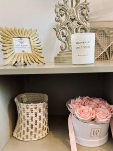 une étagère avec un bouquet de roses et une boîte de fleurs dans l'établissement La Maison Au Bois Dormant, à Barraux