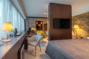 Una habitación de hotel con una cama y una sala de estar. en HOTEL AGAPE, en Bar 37 fotos más