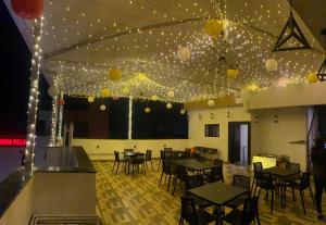 a dining room with tables and chairs and lights at Hotel Golden Bliss in Bhopal