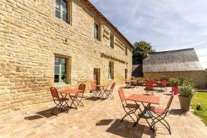 un patio con mesas y sillas frente a un edificio en Domaine du Clégrio, en Guéhenno