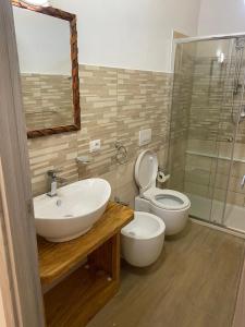 bagno con lavandino, servizi igienici e specchio di Appartamento da Antonio a Parghelia