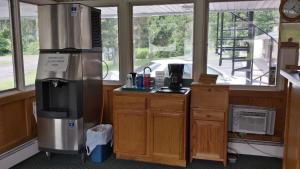a room with a kitchen with a refrigerator and a counter at Budget Inn Fairport in Fairport