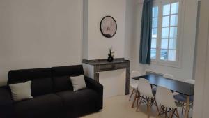 ein Wohnzimmer mit einem Sofa und einem Tisch in der Unterkunft Appartement 7 - T3 70m2 - Standing, moderne et tout équipé - Carmes-Renforts , Toulouse in Toulouse